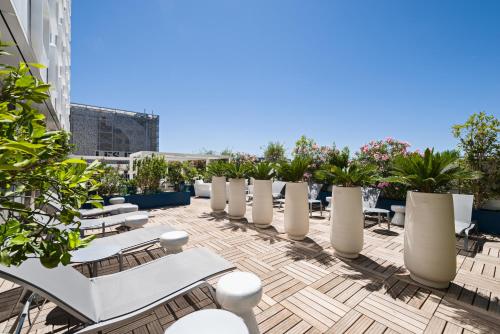 a row of white chairs on the roof of a building at Golden Tulip Marseille Euromed in Marseille