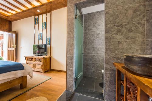 a master bedroom with a shower and a bed at Lijiang Yue Tu Inn in Lijiang