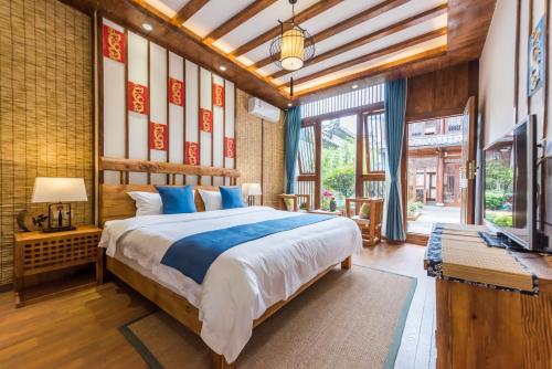 a bedroom with a large bed and a television at Lijiang Yue Tu Inn in Lijiang