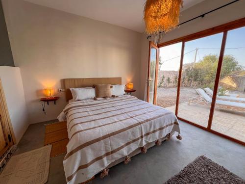 a bedroom with a large bed and a large window at Villa Amwaj 15 min from Essaouira & Sidi Kaouki in Essaouira