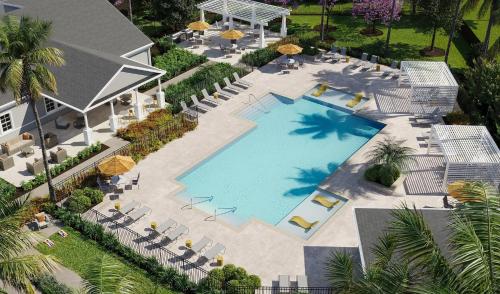 Una vista aérea de una piscina con sillas y sombrillas. en Landing Apartments Palm Bay, en Palm Bay