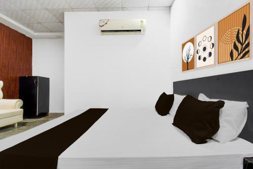 a bedroom with a bed with black and white pillows at Collection O Vrindavan Yojna Lucknow Formerly Khushboo Palace in Nilmatha