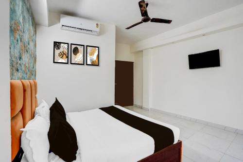 a bedroom with a bed and a ceiling fan at Super Hotel O Sector 51 Metro Station Formerly Shubham Residency in Indirapuram