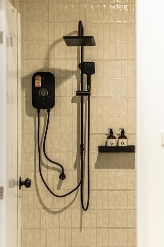 a bathroom with a shower with a blow dryer at anhaus chiangrai in Chiang Rai