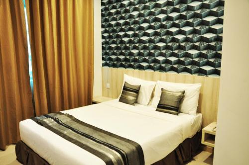 a bedroom with a large bed with a black and white wall at Valya Hotel, Ipoh in Ipoh