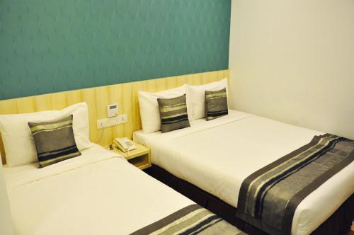 a hotel room with two beds and a telephone at Valya Hotel, Ipoh in Ipoh