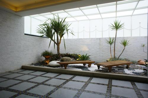 a lobby with benches and palm trees in a building at All-Ur Boutique Motel - ChungLi Branch in Pingzhen