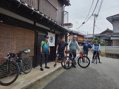 a group of people standing next to their bikes at 前の家おさき in Awaji