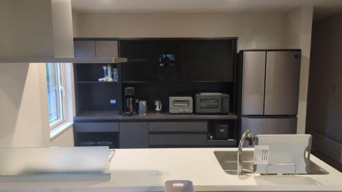 a kitchen with a sink and a refrigerator at Wakaba Niseko 新築1棟貸切 in Rankoshi