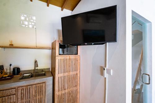 a kitchen with a flat screen tv on a wall at Loft Baan Sea Nok - Private Living Room, Kitchen, AC - Central Bingin in Uluwatu