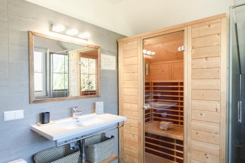 a bathroom with a sink and a mirror and a shower at Chalet Aineck Snowwhite in Sankt Margarethen im Lungau