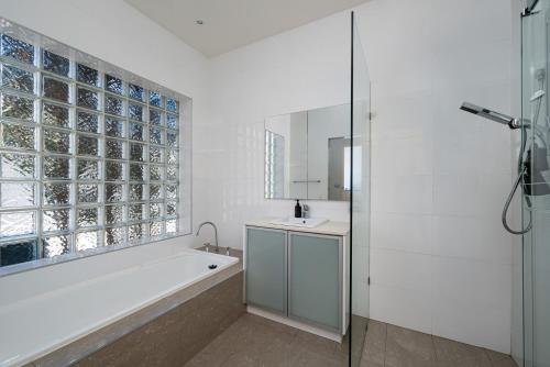 a bathroom with a tub and a sink and a mirror at Villa Solare - Pet friendly Retreat with Pool and Spa in Mount Martha