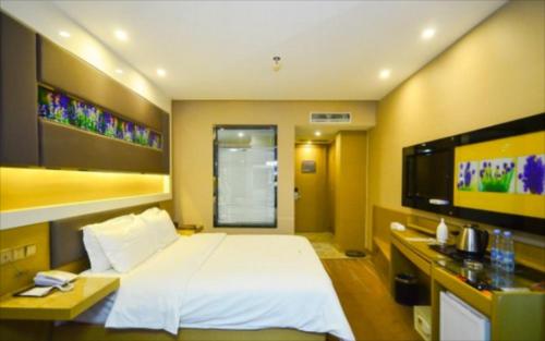 a bedroom with a large white bed and a television at Lavande Hotel Xuzhou Golden Eagle Shopping Centre in Xuzhou