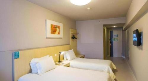 a hotel room with two beds and a tv at Magnotel Business Xuzhou Jinying Sudi Road Metro Station in Xuzhou