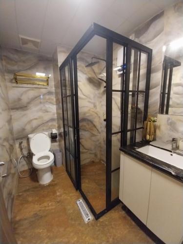 a bathroom with a toilet and a sink at Apartemen SKY HOUSE BSD in Samporo