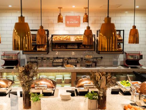 una cucina con un mucchio di cibo in esposizione di Mercure Sydney a Sydney