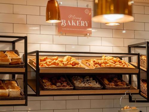 una panetteria con molti tipi diversi di prodotti da forno esposti di Mercure Sydney a Sydney