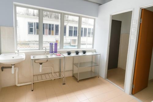 ein Badezimmer mit Waschbecken und Toilette und einem Fenster in der Unterkunft TK Homie in Tanjung Karang