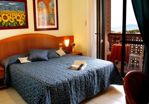 a bedroom with a bed with two books on it at Hotel Ariston in Marina di Grosseto