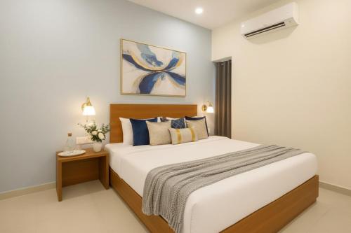 a bedroom with a large bed with blue pillows at Hotel Grand Stay Park Near Ameerpet Metro Station & GVK One Mall in Hyderabad