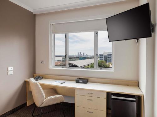 a room with a desk with a window and a desk at ibis Sydney Olympic Park in Sydney