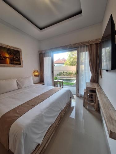 une chambre avec un grand lit et une grande fenêtre dans l'établissement Casa Benoa Homestay, à Nusa Dua