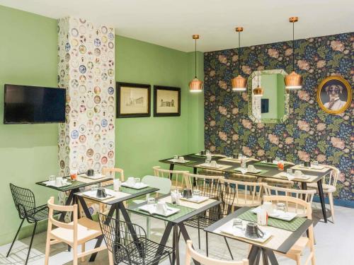 a dining room with tables and chairs and green walls at ibis Styles Paris Gare de l'Est TGV in Paris