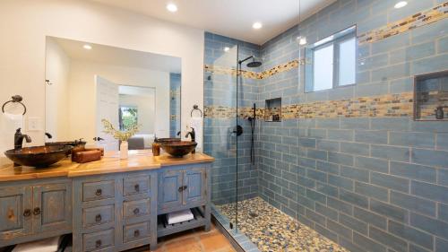 une salle de bain avec deux lavabos et une douche dans l'établissement Sleeps 20 Architectural Mansion w Pool Indoor Tennis Court Game Room Starlight Estate by AvantStay, à Bermuda Dunes