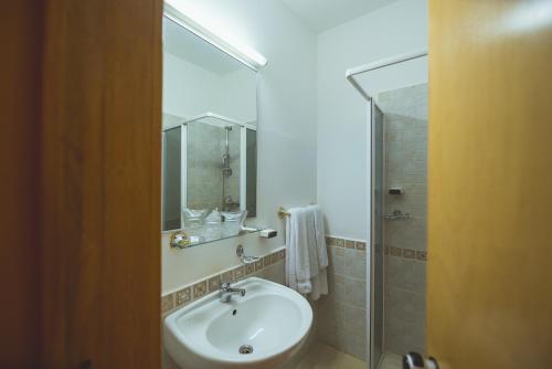 a bathroom with a white sink and a shower at Hotel Belvedere in Predeal