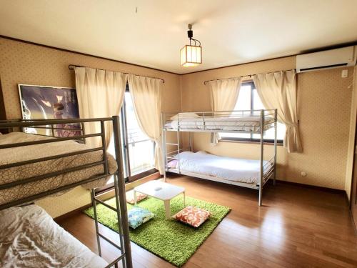 a bedroom with two bunk beds and a green rug at Kamakura Guest House 3 Bedrooms, Sleeps 10 in Kamakura