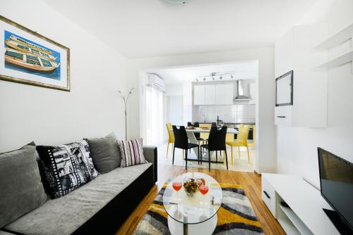 a living room with a couch and a table at Holiday home Orange with heated pool and parking in Zadar