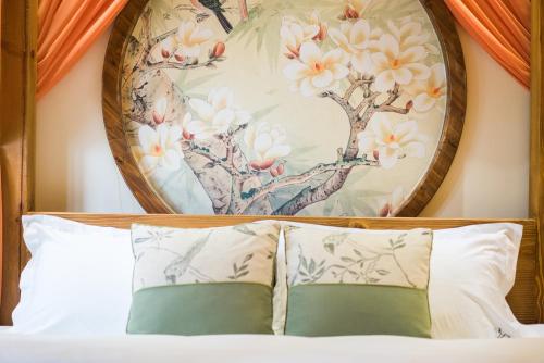 a bedroom with a painting above a bed with pillows at Lijiang Yue Tu Inn in Lijiang
