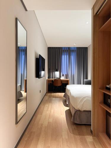 a hotel room with a bed and a mirror at Ibis Ambassador Suwon in Suwon