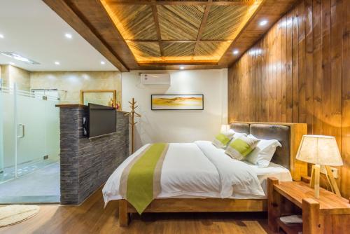 a bedroom with a bed and a tv and a tub at Lijiang Yue Tu Inn in Lijiang