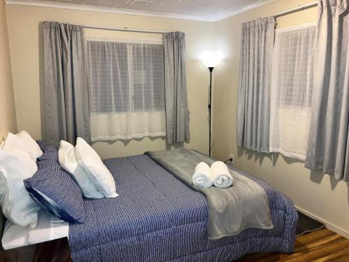 una camera da letto con un letto con due asciugamani sopra di The Sandy Jandal a Karikari Peninsula