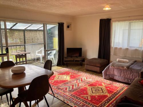 un soggiorno con divano e tavolo con tappeto di The Sandy Jandal a Karikari Peninsula