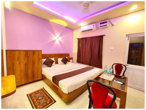 a bedroom with a bed and a table and chairs at Hotel Blusesagar Residency Near Sea Beach And Jagannath Temple in Puri