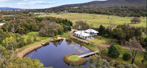 an aerial view of a house and a lake at Lakeside haven cottage - Macedon ranges in Riddell