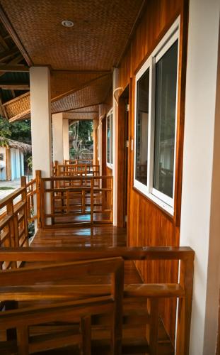 a row of wooden benches in a church with windows at Seaside Beach Hostel in San Vicente