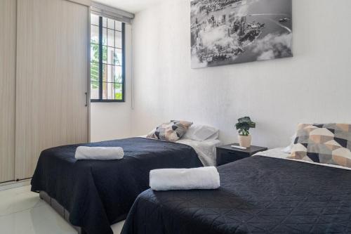a room with two beds and a window at Departamento en condominio con alberca excelente ubicación in Manzanillo