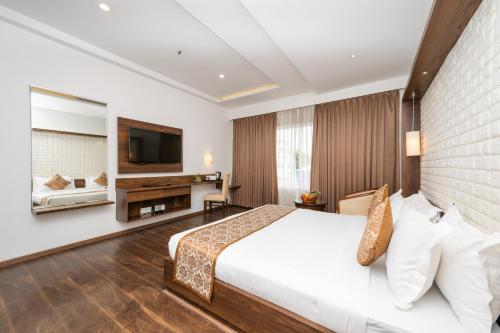 a hotel room with a bed and a television at The Liverpool Hotels Marathahalli, Outer Ring Road in Bengaluru
