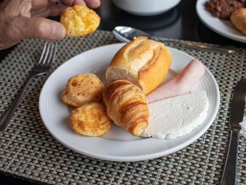 um prato de comida com pão e salsicha sobre uma mesa em Novotel Sao Paulo Center Norte em São Paulo