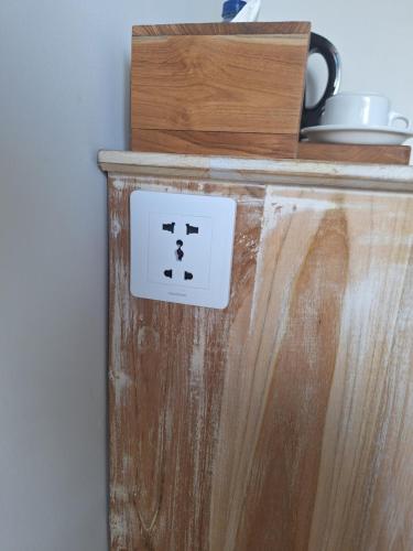 a lightswitch on a wooden cabinet in a room at Casa Benoa Homestay in Nusa Dua