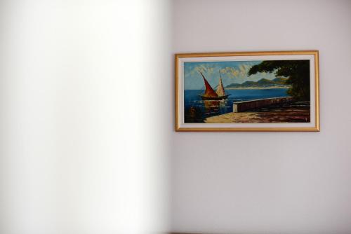 a painting of a sail boat on a wall at Holiday home Orange with heated pool and parking in Zadar