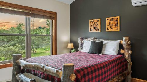 a bedroom with a bed with a large window at Otter Banks by AvantStay Sleeps 18 Hot Tub Views Game Room in Albrightsville