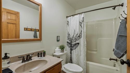 a bathroom with a sink and a toilet and a shower at Otter Banks by AvantStay Sleeps 18 Hot Tub Views Game Room in Albrightsville