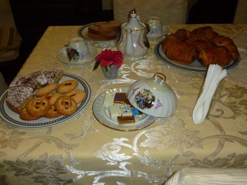 ピサにあるB&B Carlaのテーブルに盛り付けられた食べ物とペストリー