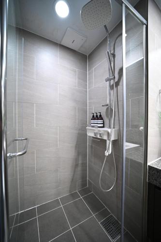 una ducha con puerta de cristal en un baño en Stay in WAVE, en Kwangan-dong