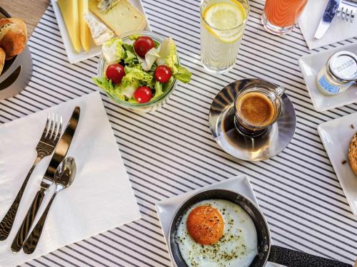 a table with a bowl of eggs and a salad at Mercure Marseille Centre Prado Vélodrome in Marseille