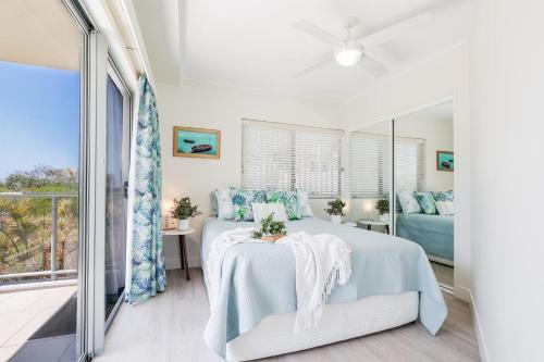 アグネス・ウォーターにあるPavillions Ocean Breeze Apartment 119のベッドとバルコニーのある寝室